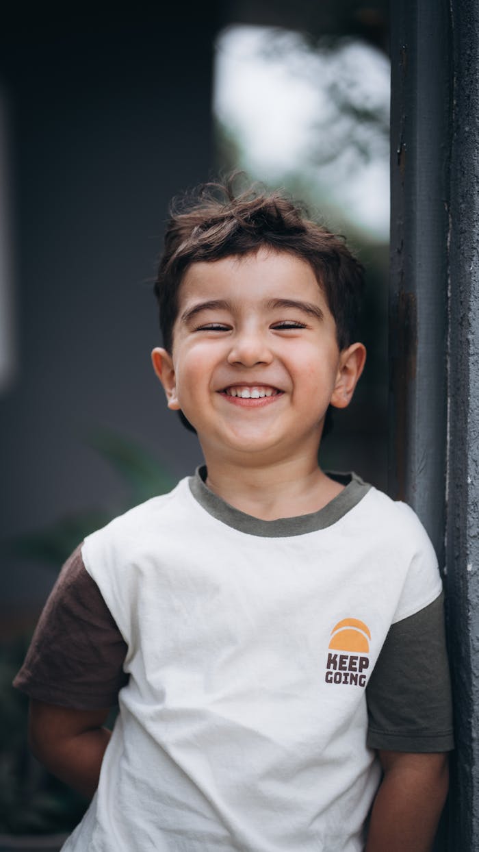 A cheerful child wearing a 'Keep Going' t-shirt, exuding joy.