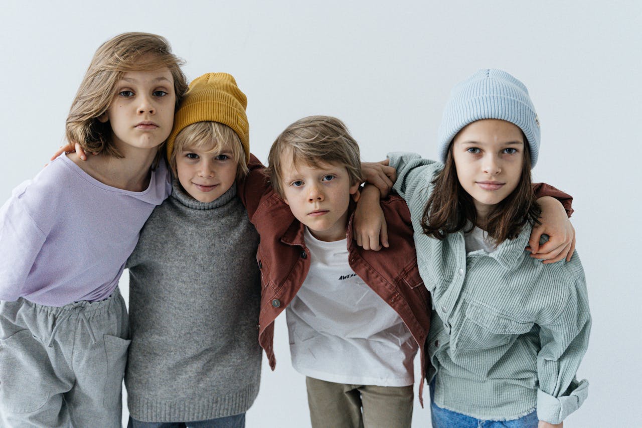 services-header Children posing together in trendy casual outfits with hats indoors.