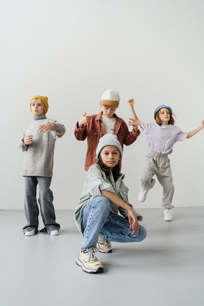 Group of stylish children posing in modern fashion outfits against a white background.